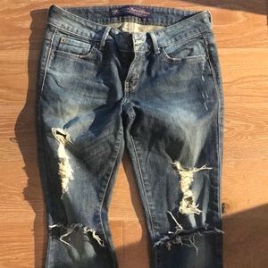 Rip and distressed blue jeans with cut off bottom